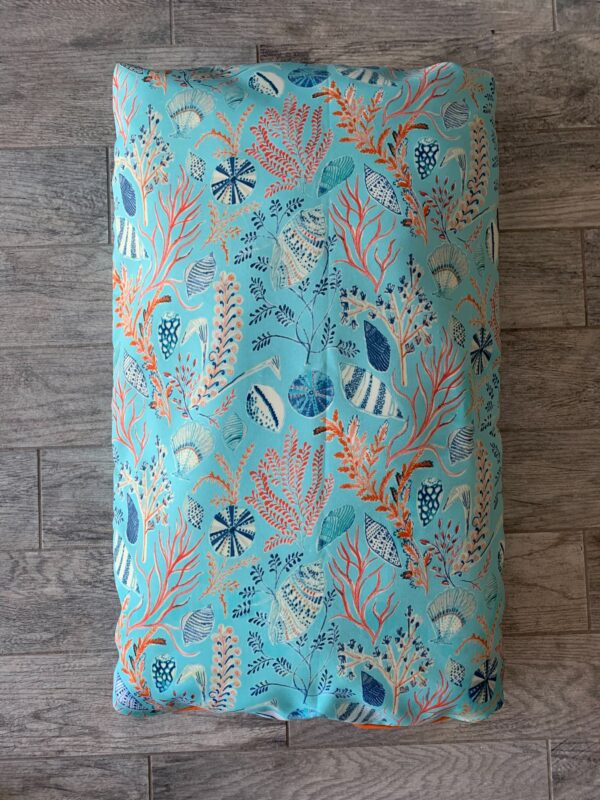 A blue colored dog bed bag with different color designs printed on it