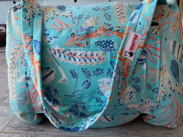 A blue dog bed bag from DoggyToGo with different kinds of patterns printed on it