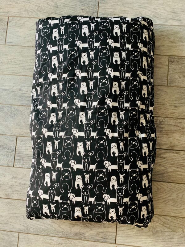 An image of a black dog bed bag on the floor captured from the top angle