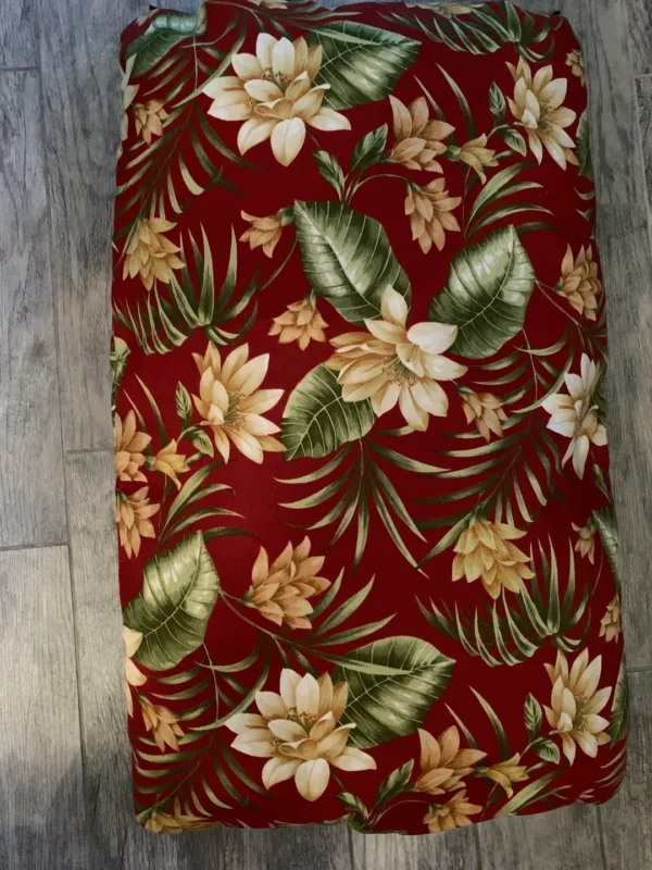 A red dog bed bag with multicolored flower prints on it kept on the floor