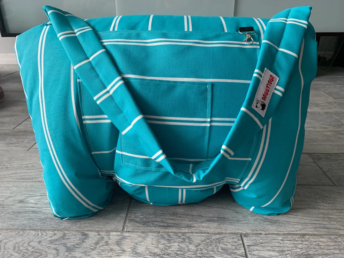 A blue dog bed bag with white stripes