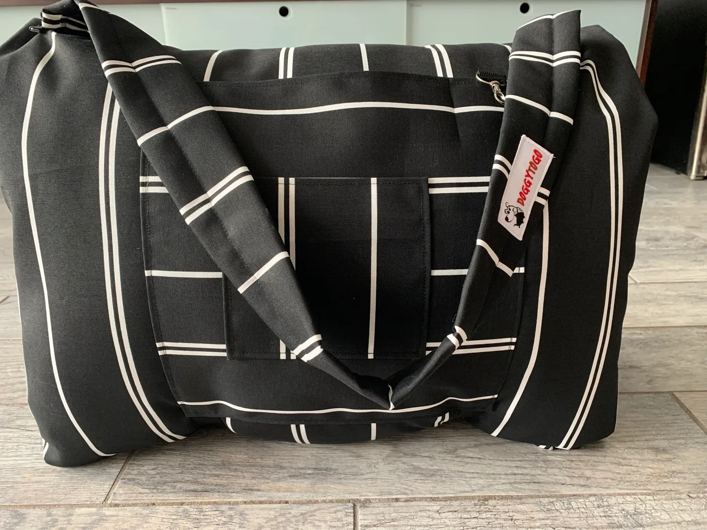 A black dog bed bag with white stripes