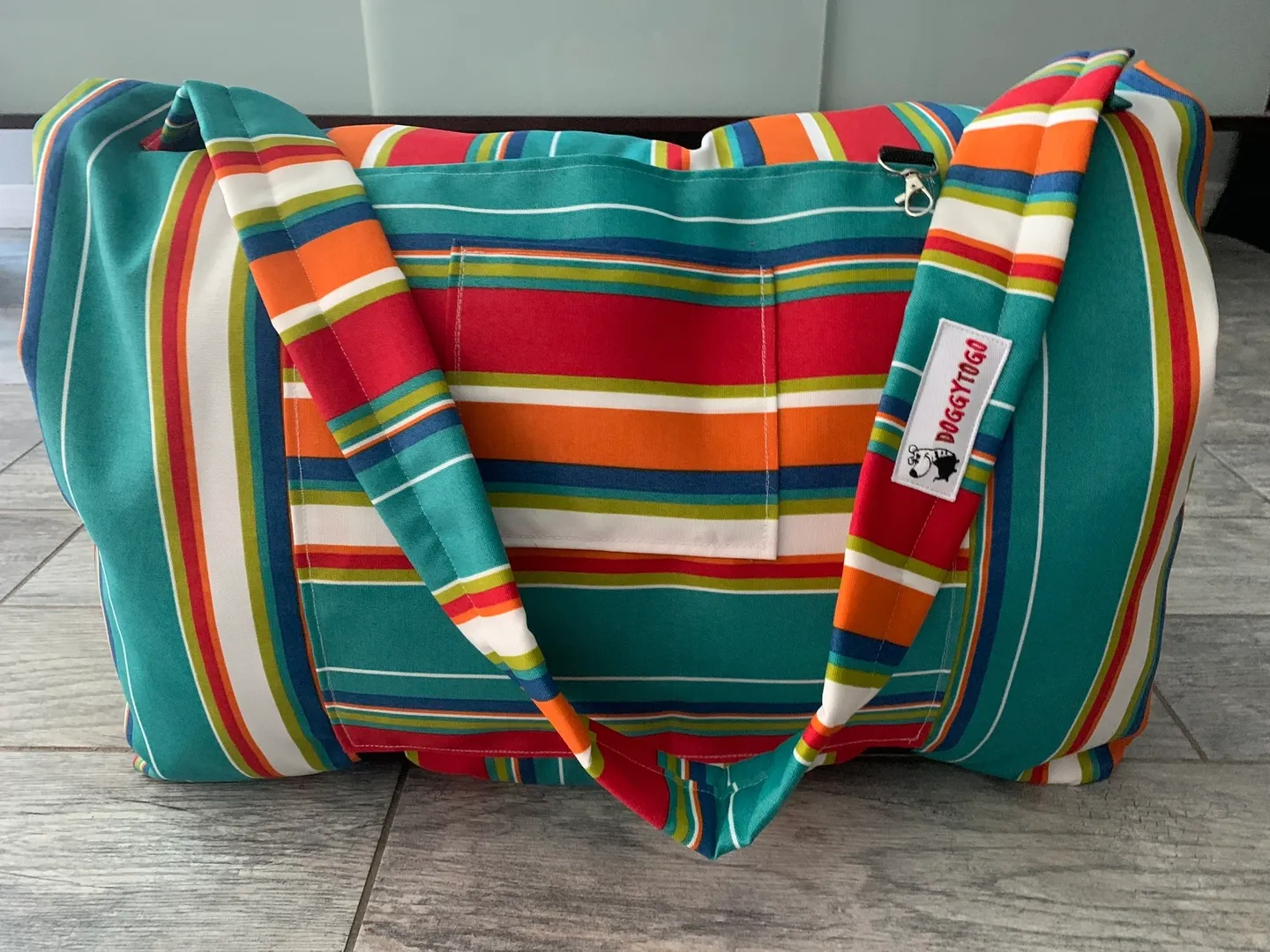A dog bed bag with multicolor stripes