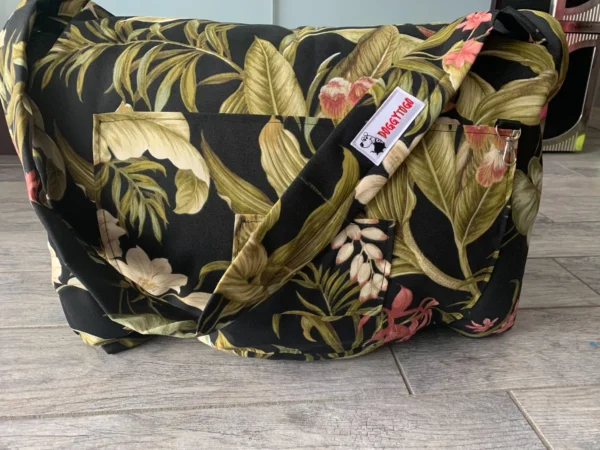 A black color dog bed bag with patterns of leaves and flowers