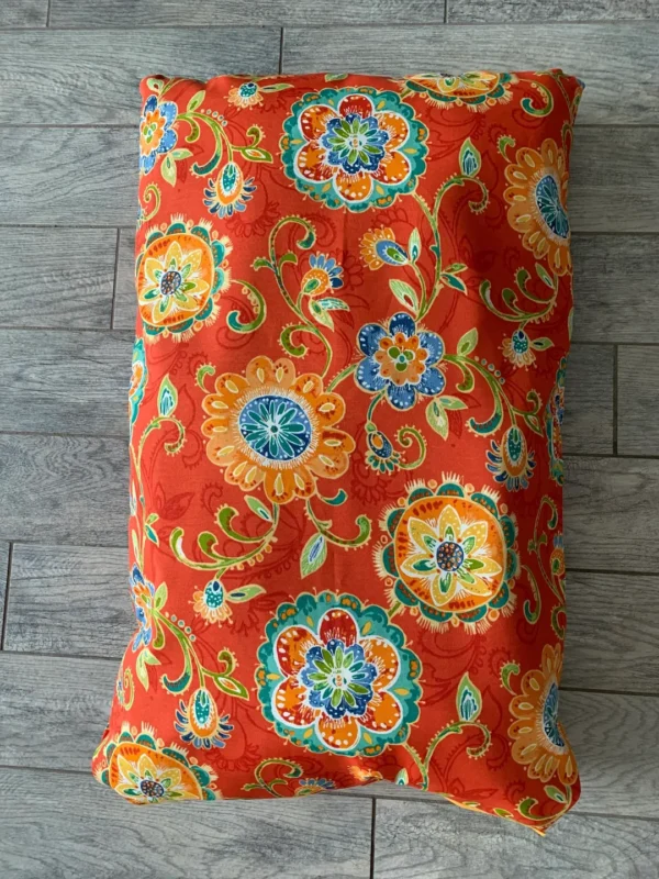 Tiny photograph of an orange-colored dog bed bag with the design of flowers on it