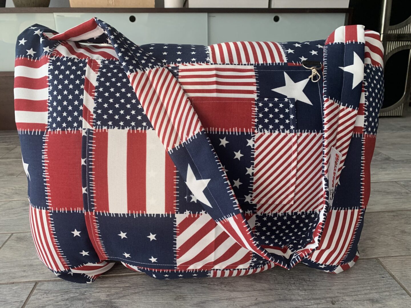 A dog bed bag with the pattern of the USA flag printed on it