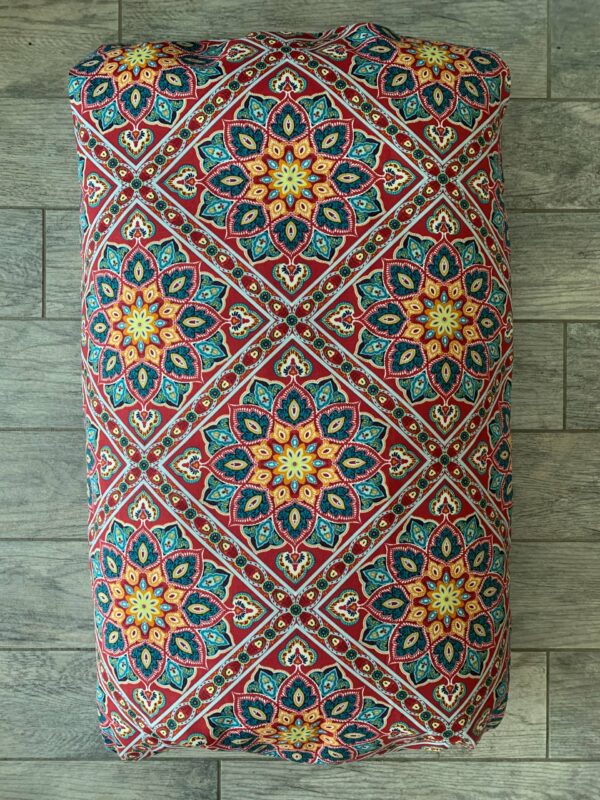 A multicolor dog bed bag kept on the floor