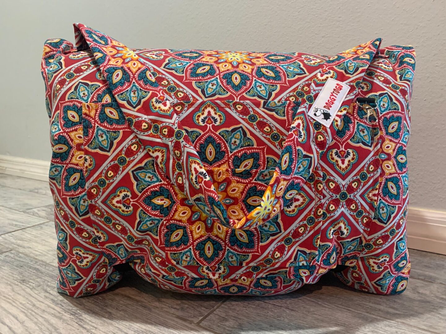 A dog bed bag with a multicolor pattern printed on it